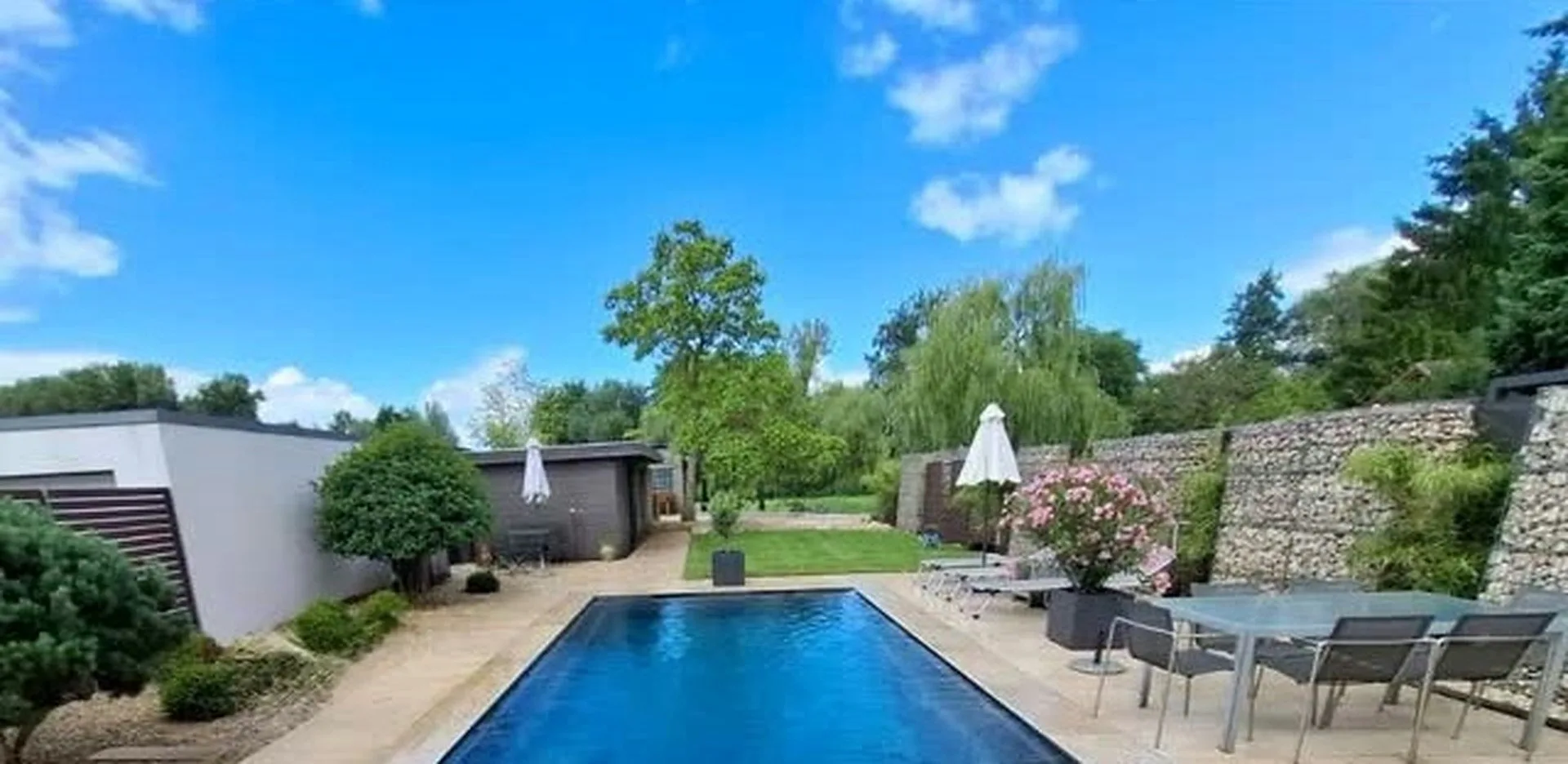 Pool mit Natursteinterrasse und Gabionen